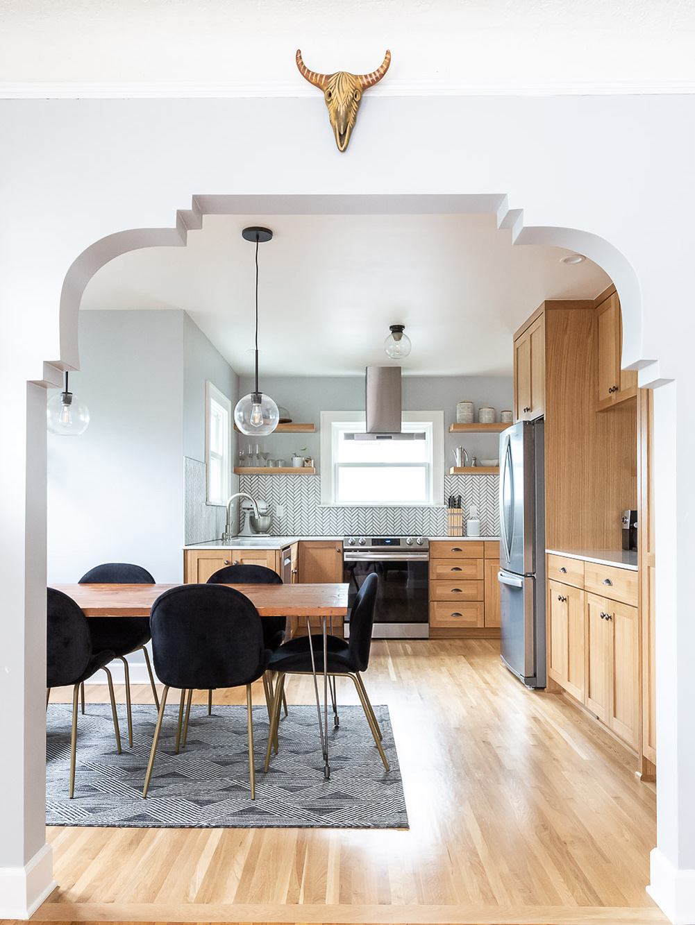 View through the reconstructed decorative archway from the entry into the dining room and kitchen beyond, Arbor Lodge Kitchen remodel by Tweto Architecture