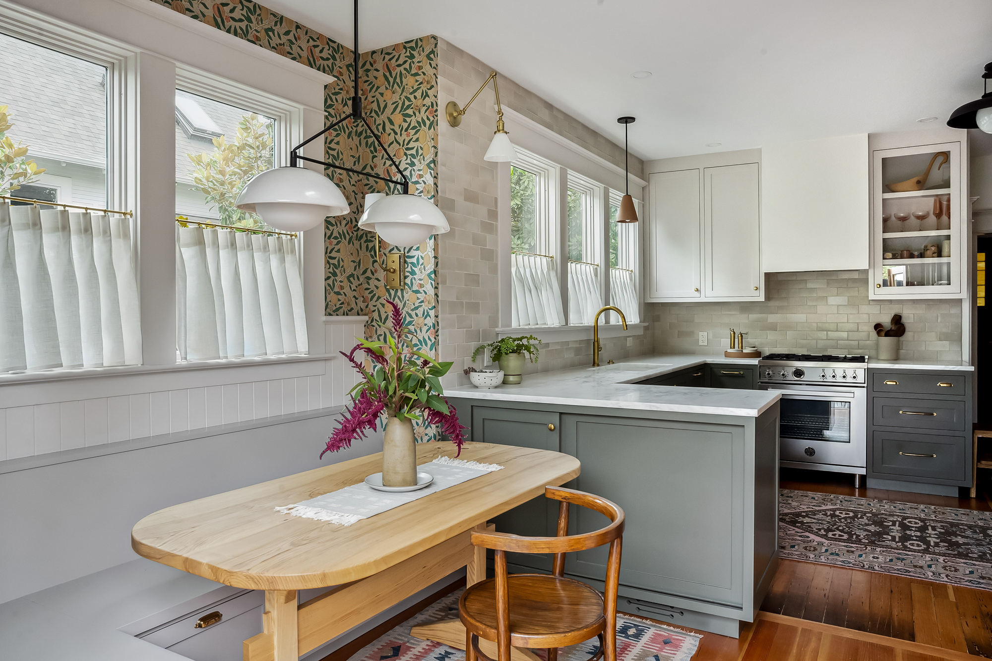 Breakfast nook with built-in bench and table, botanical wallpaper, looking toward the kitchen sink and windows, Baldwin Street remodel by Tweto Architecture