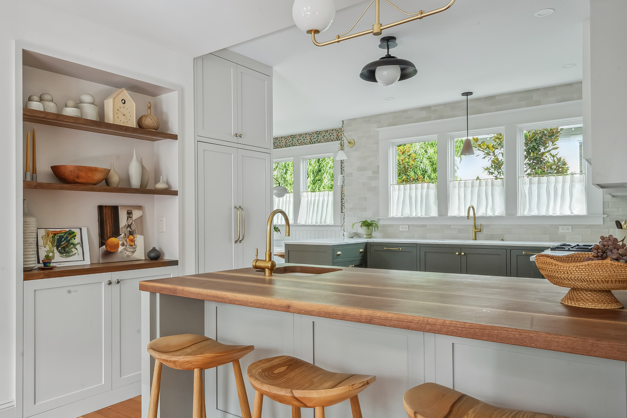 Remodeled kitchen with island, walnut countertop, bar stools, and open shelves, looking toward the windows and sink, Baldwin Street remodel by Tweto Architecture