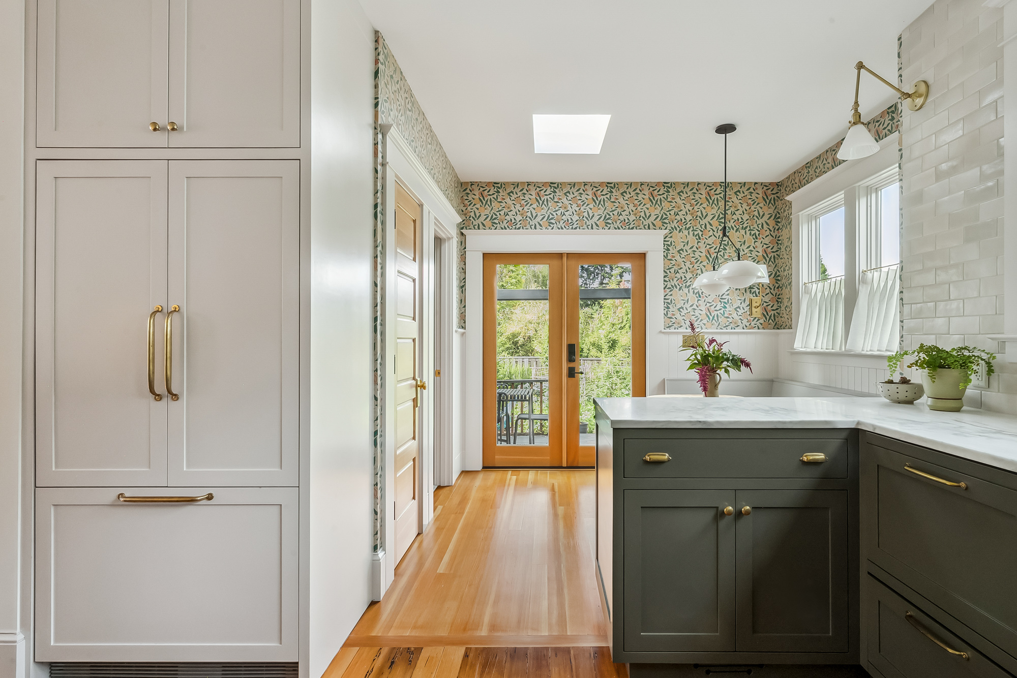 View through the rebuilt addition toward the french doors at the end, with tall pantry cabinets at left and kitchen peninsula at right, Baldwin Street remodel by Tweto Architecture