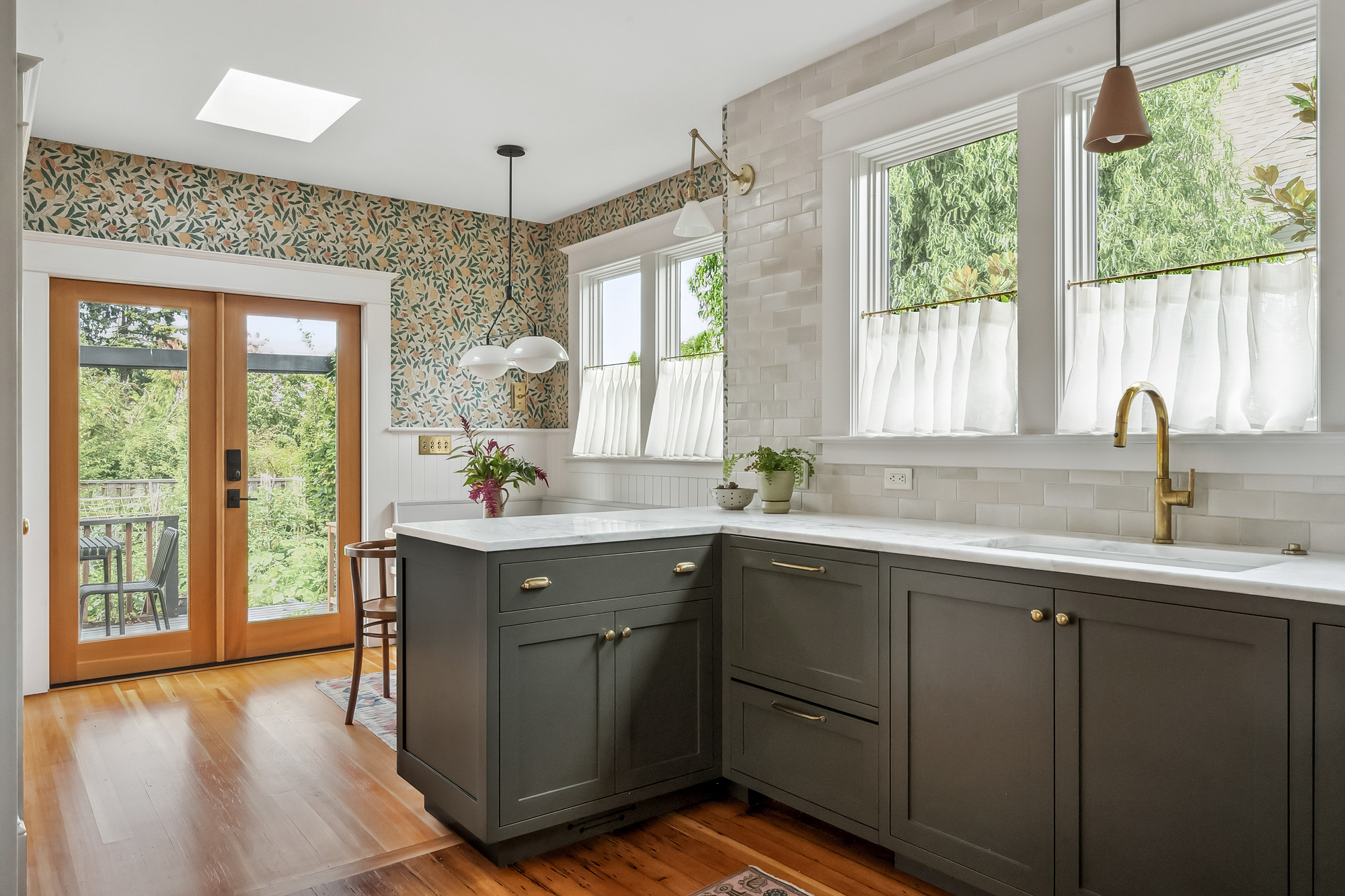 Kitchen looking toward the french doors, with botanical wallpaper, skylight, and sink wall at right, Baldwin Street remodel by Tweto Architecture