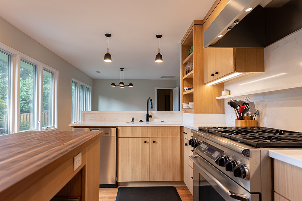 New kitchen with walnut island, oak cabinets, and south-facing casement windows, Brooklyn Street remodel by Tweto Architecture, SE Portland