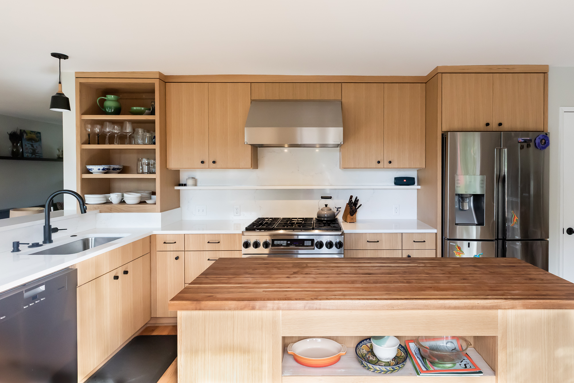 Wide view of new kitchen showing walnut island, range wall with open shelves, and refrigerator, Brooklyn Street remodel by Tweto Architecture