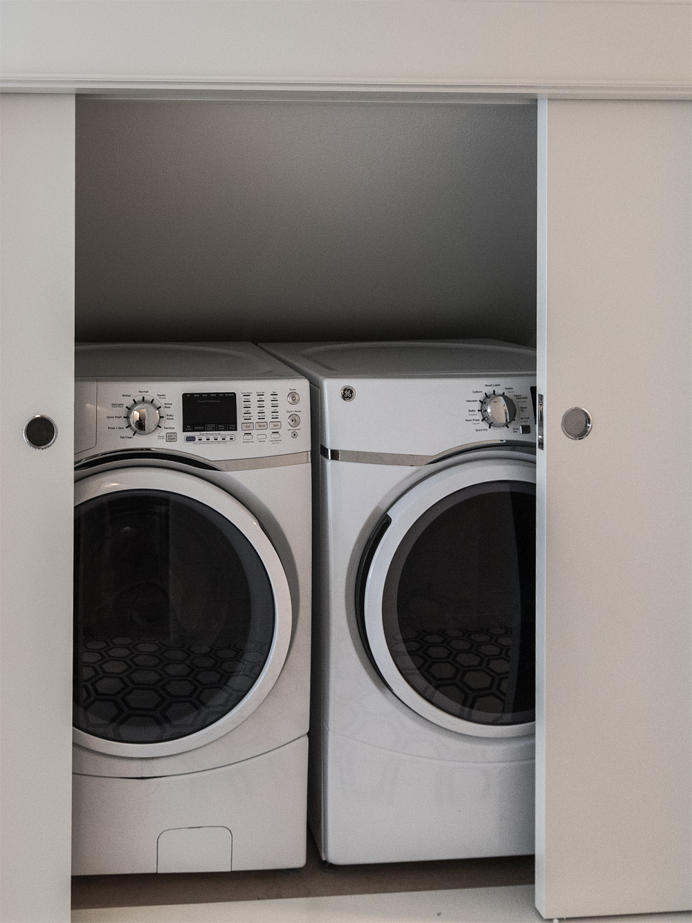 Washer and dryer in closet behind sliding doors, Carolina Primary Suite addition by Tweto Architecture