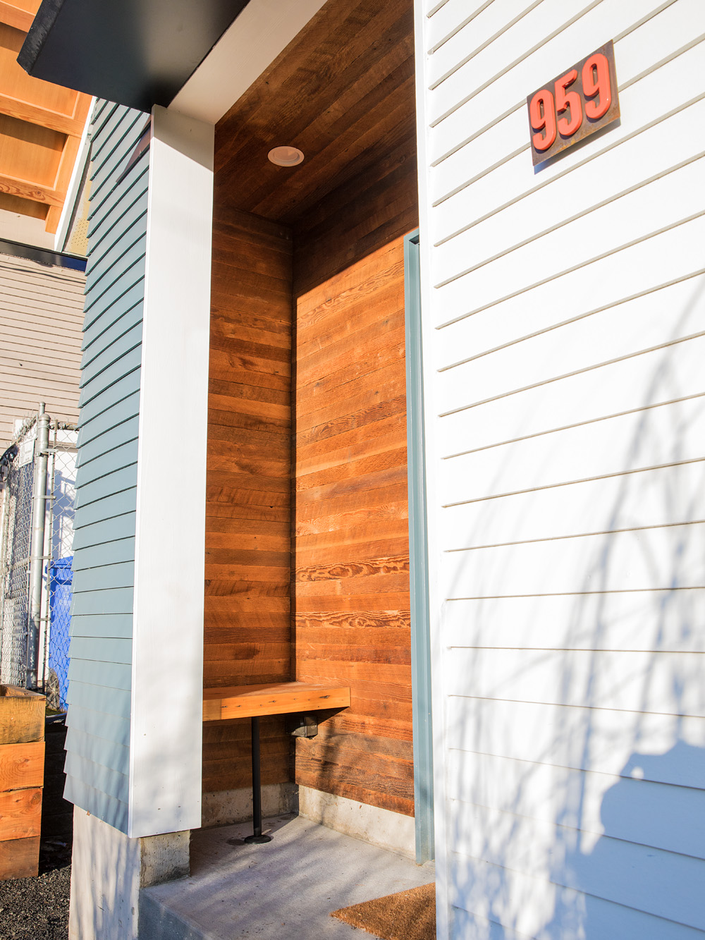 Recessed entry porch lined with salvaged fir cladding, house number 959 on the facade, Mason Street ADU by Tweto Architecture