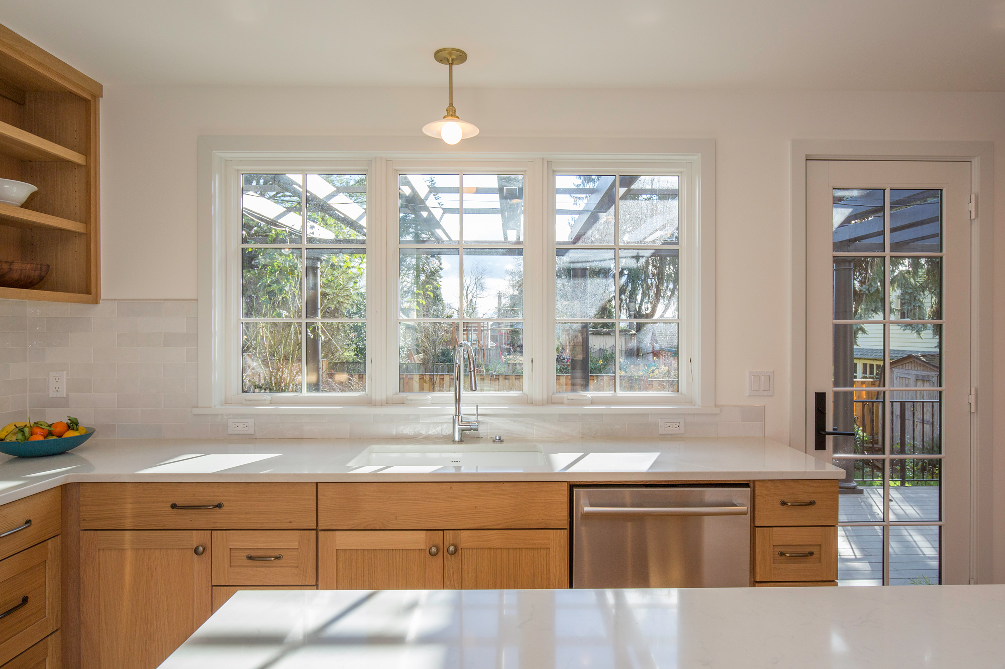 Kitchen sink and three south casement windows with glass back door to the backyard at right, Mt. Tabor Tudor remodel by Tweto Architecture