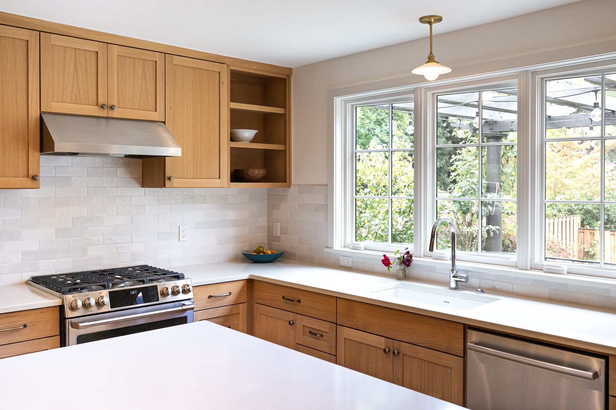 Kitchen range and sink wall with three south casement windows letting in afternoon light, Mt. Tabor Tudor remodel by Tweto Architecture