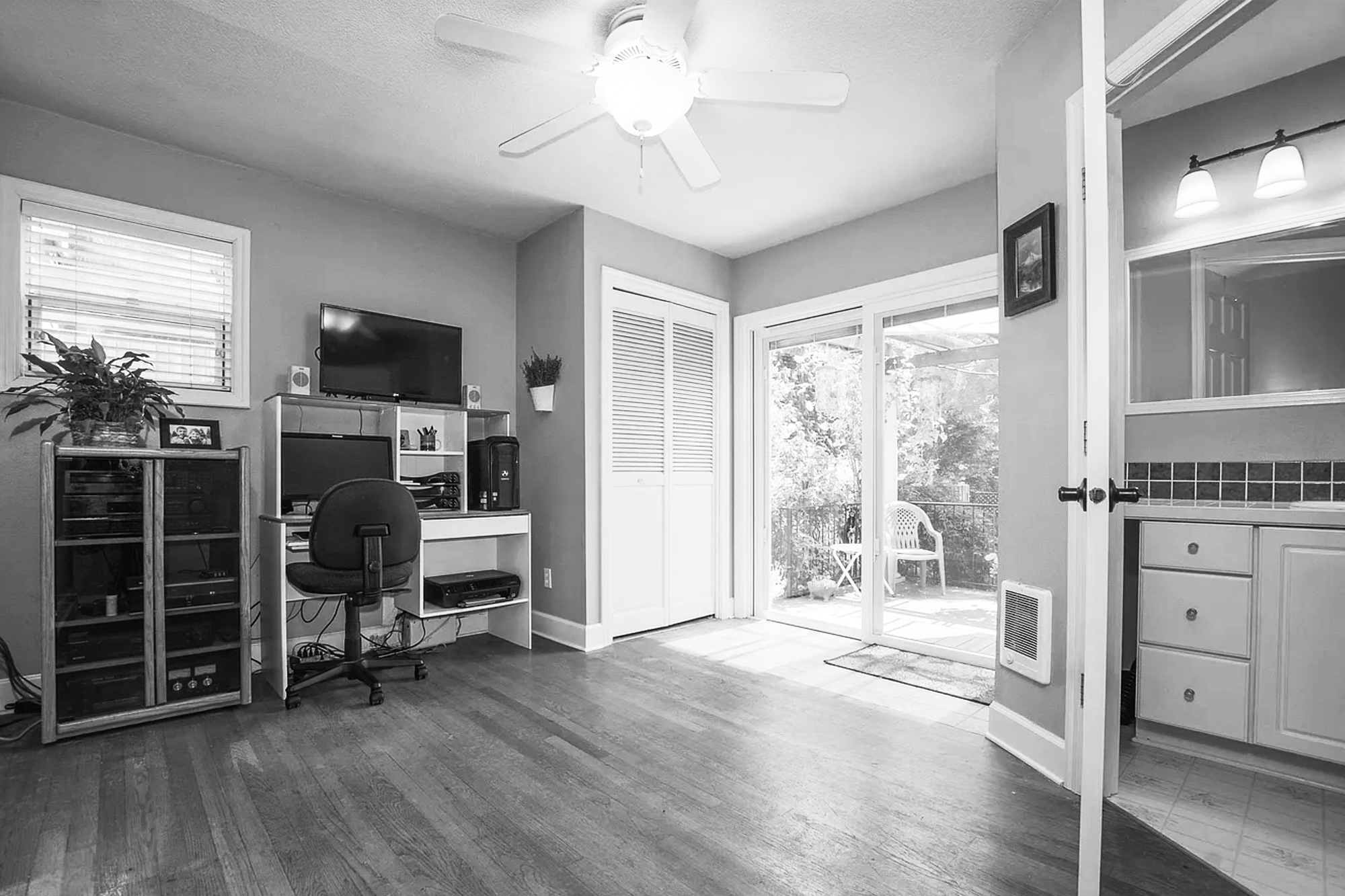 Existing rear addition used as home office before remodel, with sliding door to backyard and adjacent galley kitchen at right, Mt. Tabor Tudor remodel by Tweto Architecture
