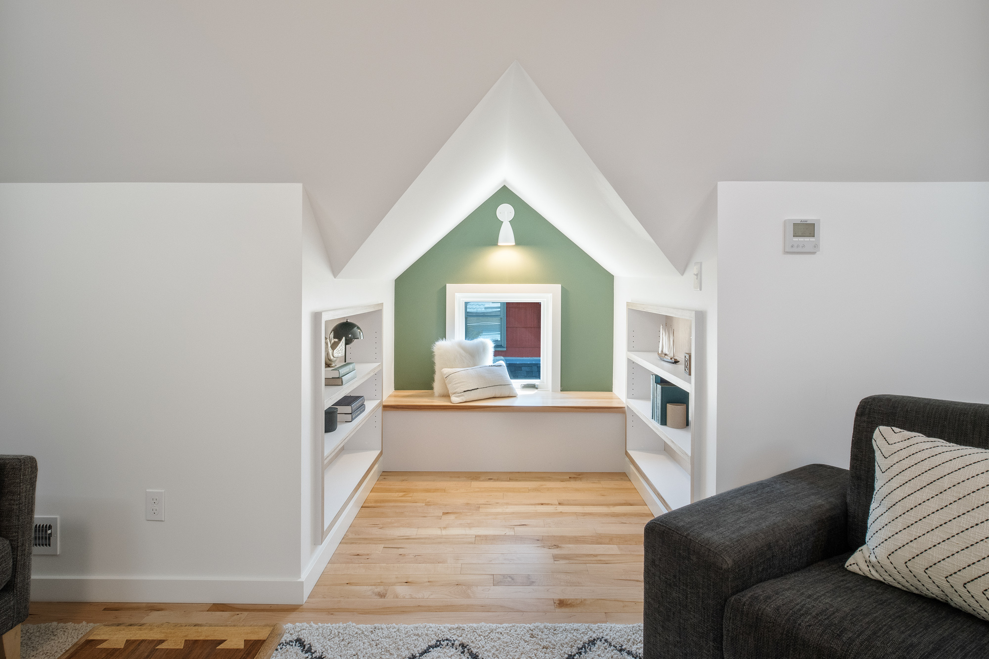 Dormer reading niche with window seat and flanking built-in shelves painted sage green inside, NE 9th Remodel by Tweto Architecture