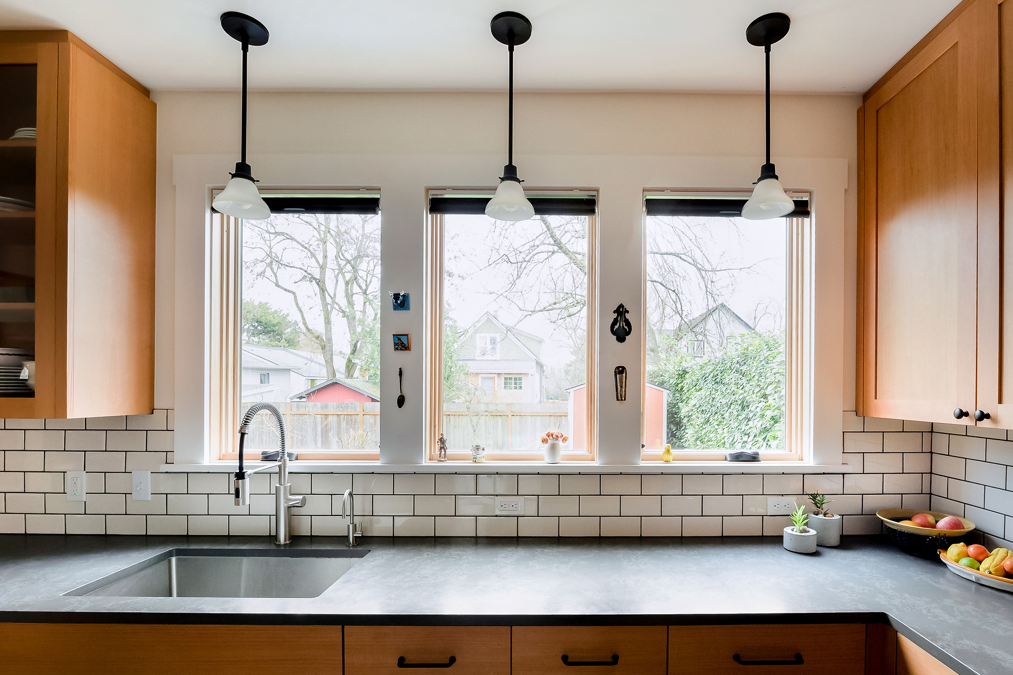 Three new east-facing windows above the sink with matching pendant lights, bringing backyard views into the kitchen, Sabin Kitchen by Tweto Architecture